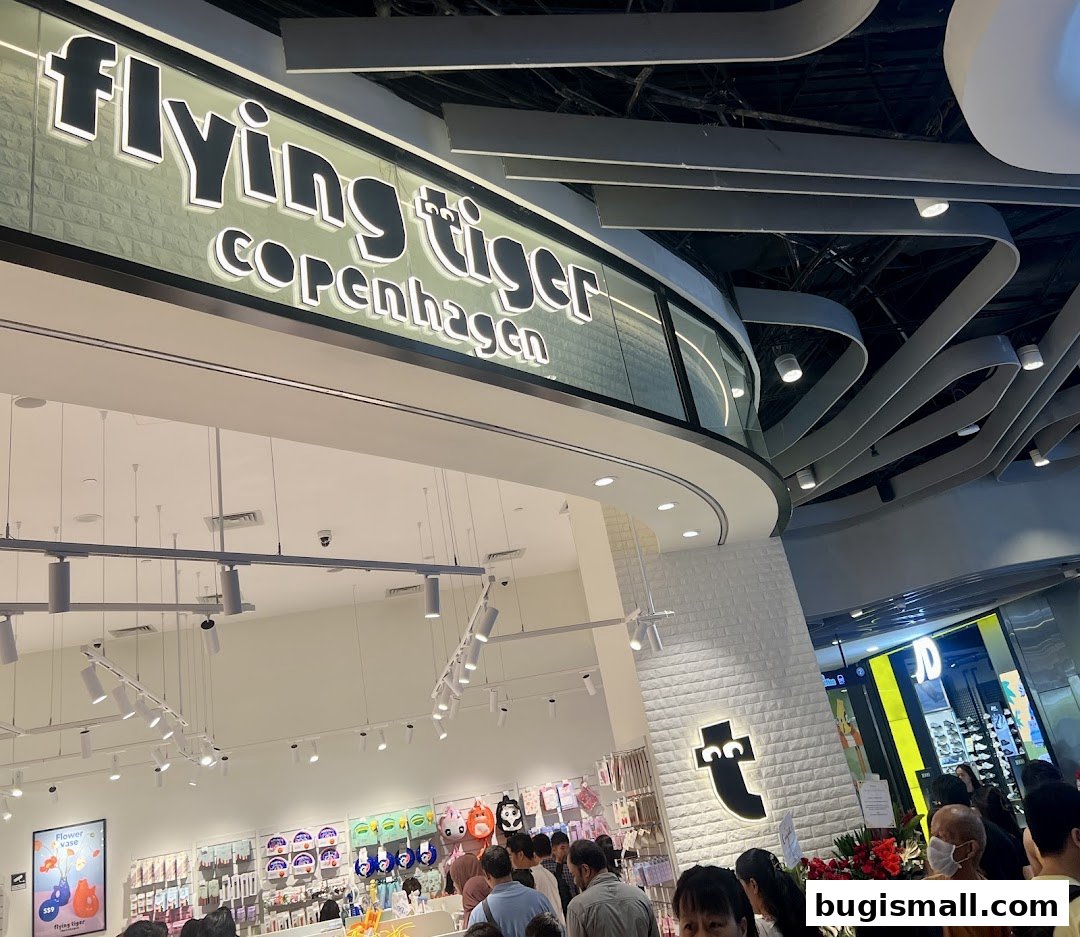 The entrance of a Flying Tiger Copenhagen store with its distinctive logo and bright interior.
